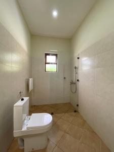 a white bathroom with a toilet and a shower at Maasai Koroga in Mombasa