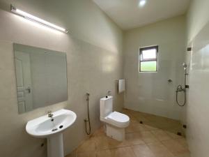 a bathroom with a sink and a toilet and a mirror at Maasai Koroga in Mombasa