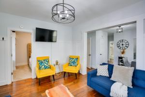 a living room with a blue couch and two yellow chairs at Atlantic City Home about 2 Mi to Ocean Casino Resort! in Atlantic City