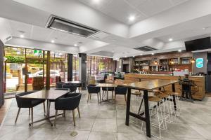 a restaurant with tables and chairs and a bar at Econo Lodge North Adelaide in Adelaide