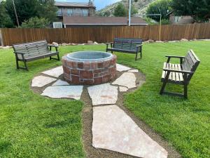 two park benches and a fire pit in a yard at Zion Canyon Cabins in Springdale