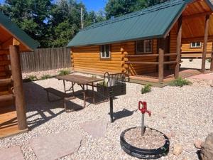 a log cabin with a picnic table and a playground at Zion Canyon Cabins in Springdale