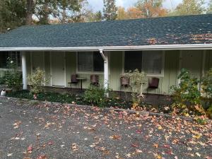 a house with chairs and a porch with leaves on the ground at Seven Circles Lodge&Retreat in Badger