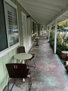 a covered porch with chairs and tables and windows at Seven Circles Lodge&Retreat in Badger