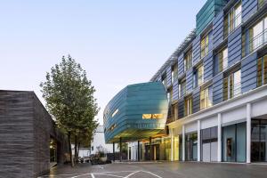 ein Bürogebäude mit Glasfassade in der Unterkunft Vienna House by Wyndham Martinspark Dornbirn in Dornbirn