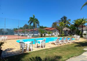 a group of chairs and a pool with a bunch of tables and chairs at Acquamarine Park Hotel in Guarapari