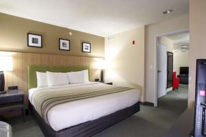 A bed or beds in a room at Country Inn & Suites by Radisson, West Valley City, UT