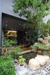 a garden with a pond in front of a building at Einhan Resort in Yuchi