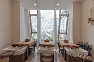 une salle de thérapie avec trois lavabos et une fenêtre dans l'établissement Jodi Dalat Hotel, à Đà Lạt