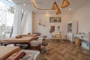 Cette chambre comprend un salon avec une table et des chaises. dans l'établissement Jodi Dalat Hotel, à Đà Lạt