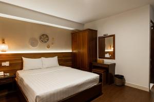 a small bedroom with a bed and a mirror at Lantern Hotel in Ho Chi Minh City