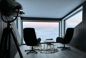 a camera and two chairs and a table in front of a window at Arctic Sea Breeze in Kirkenes