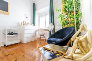 - un salon avec une chaise et un livre sur une table dans l'établissement April Square by Lisbon with Sintra, à Amadora