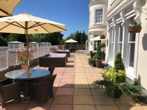 チェルトナムにあるDoubleTree by Hilton Cheltenham-Cotswoldsの屋外パティオ(テーブル、傘付)