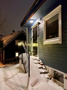 a house with snow on the steps and a window at Cosy house with sunny terrace, garden and fjord view in Bergen