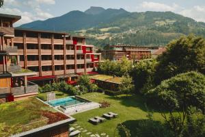 a resort with a swimming pool and some buildings at MalisGarten Green Spa Hotel in Zell am Ziller