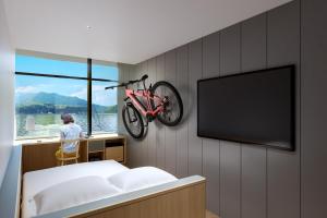 een persoon in een stoel met een fiets aan een muur bij BONAPOOL in Onomichi