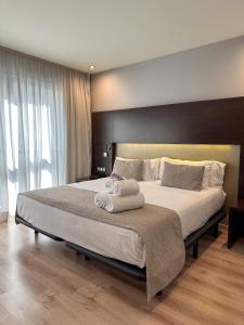 a bedroom with a large bed with towels on it at Turia Granada in Granada