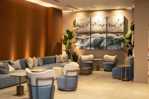 ein Wartezimmer mit blauen Sofas und Hockern in der Unterkunft Smart Brickell Hotel in Miami