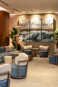 eine Lobby mit Sofas, Stühlen und Gemälden an der Wand in der Unterkunft Smart Brickell Hotel in Miami