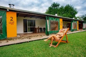 uma mulher sentada numa cadeira em frente a uma casa em Altavista TERRA em Colón