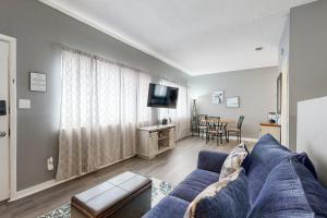 a living room with a blue couch and a tv at Okaloosa Island Studio in Fort Walton Beach