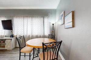 a dining room table and chairs in a room at Okaloosa Island Studio in Fort Walton Beach