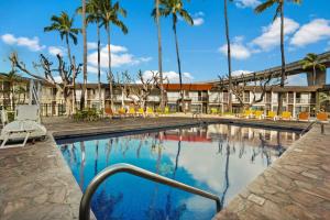 ein Pool mit Palmen und ein Gebäude in der Unterkunft Best Western The Plaza Hotel Honolulu Airport - Free Breakfast in Honolulu