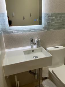 a bathroom with a white sink and a mirror at Newly Remodeled Family Friendly 3B/2B House in Henderson