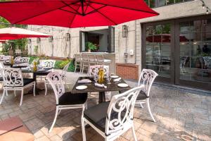 een patio met tafels en stoelen en een rode parasol bij Hampton Inn & Suites Fairfield in Fairfield