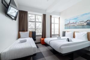 ein Hotelzimmer mit 2 Betten und Fenstern in der Unterkunft easyHotel Maastricht City Centre in Maastricht