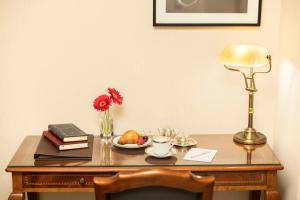 a desk with a plate of food and a lamp at Melia Recoleta Plaza Hotel in Buenos Aires