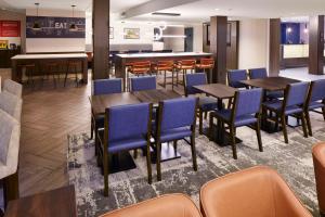 een restaurant met houten tafels en blauwe stoelen bij Hampton Inn Newark Airport in Newark