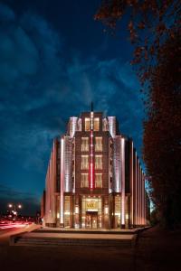 een groot gebouw met 's nachts verlichting bij Grand Hotel Valies in Roermond