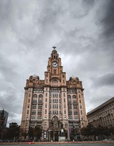 利物浦Maldron Hotel Liverpool City Centre的一座大型建筑,上面有一个钟楼