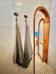 a bathroom with two towels hanging on a wall next to a mirror at Abdi Hotel in Gili Trawangan