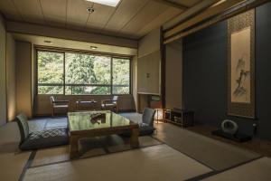 sala de estar con mesa y ventana grande en Takamiya Bettei Kuon en Tsuruoka