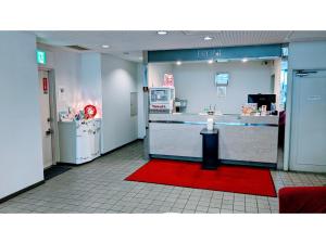 千叶Hotel Tetora Makuhari Inagekaigan - Vacation STAY 91492v的商店的大厅,有柜台和红色地毯