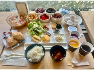 千叶Hotel Tetora Makuhari Inagekaigan - Vacation STAY 91492v的餐桌上放着食物和碗