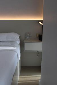 - une chambre avec un lit et 2 verres sur une étagère dans l'établissement 1 BR Luxury Apt by AJ Aljada, à Charjah