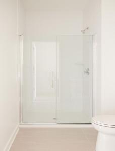 a white bathroom with a glass shower stall at ROOST Kelly Drive in Philadelphia