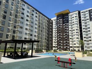 een groot appartementencomplex met een zwembad en een bank bij Iloilo Travellers Zen Zone in Iloilo City