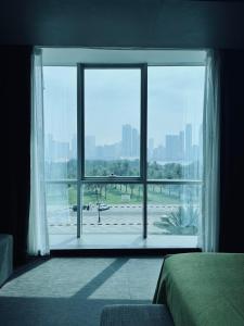 una camera da letto con una grande finestra che si affaccia su un aeroporto di Hotel 72 Sharjah Waterfront a Sharjah