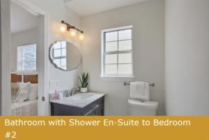 a bathroom with shower er suite to bathroom with sink and mirror at Estrella del Mar in Panama City Beach