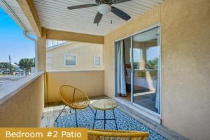 a balcony with two chairs and a ceiling fan at Estrella del Mar in Panama City Beach