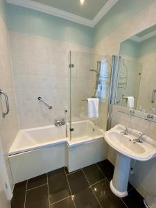 a bathroom with a tub and a sink and a shower at East Beach Hotel in Eastbourne