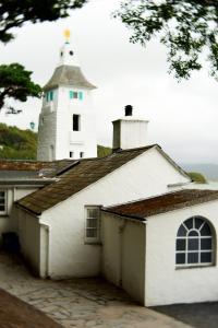 um edifício branco com um farol ao fundo em Portmeirion Village & Castell Deudraeth em Porthmadog