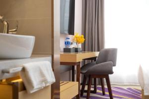 een badkamer met een wastafel en een bureau met een stoel bij Guangzhou Baiyun Airport Yunzhi Hotel near Terminal One - Complimentary Shuttle Bus between hotel to Canton Fair Complex during Canton Fair in Guangzhou