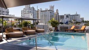 a swimming pool with chairs and umbrellas on a building at Uma House by Yurbban South Beach in Miami Beach