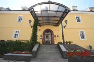 a yellow building with a staircase leading to a door at Hotel Leopold I in Novi Sad